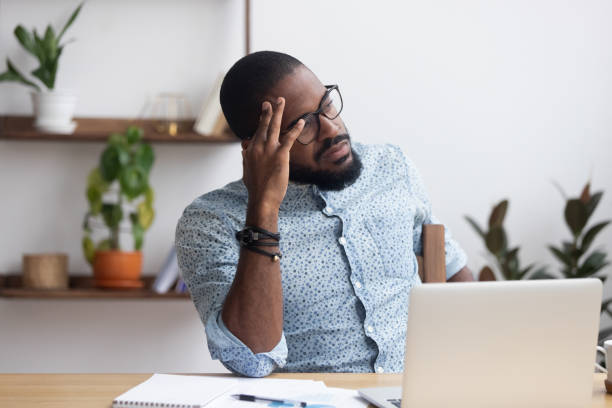 a business man looking stressed at a computer